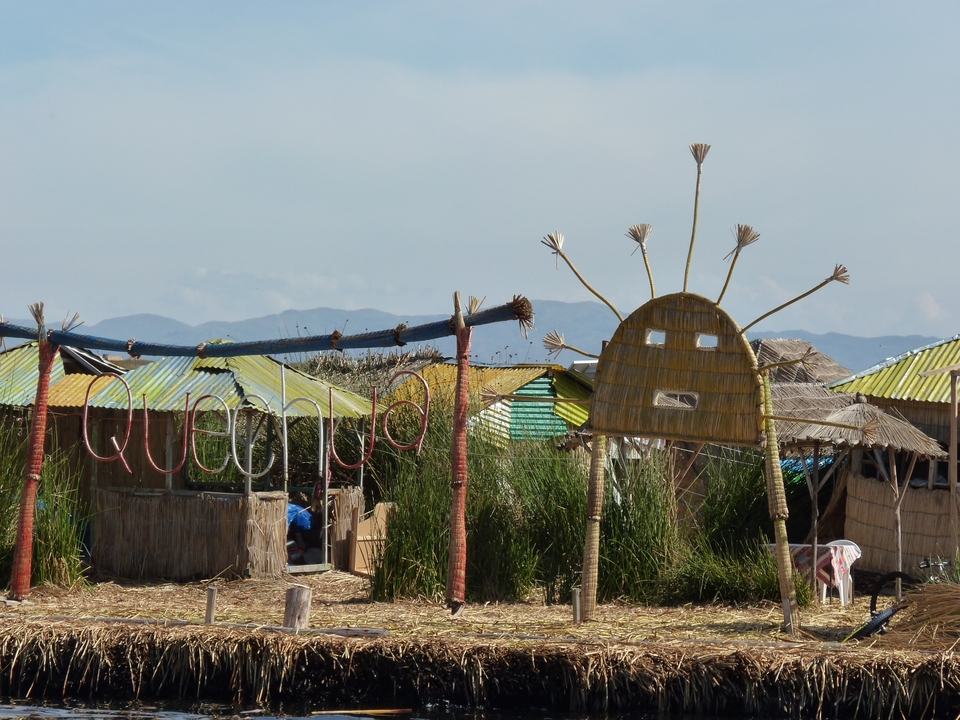 Traditional houses and structures made from reeds on a lake.