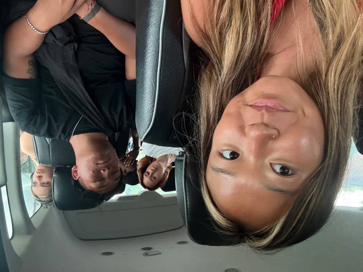 People inside a vehicle, one person asleep.