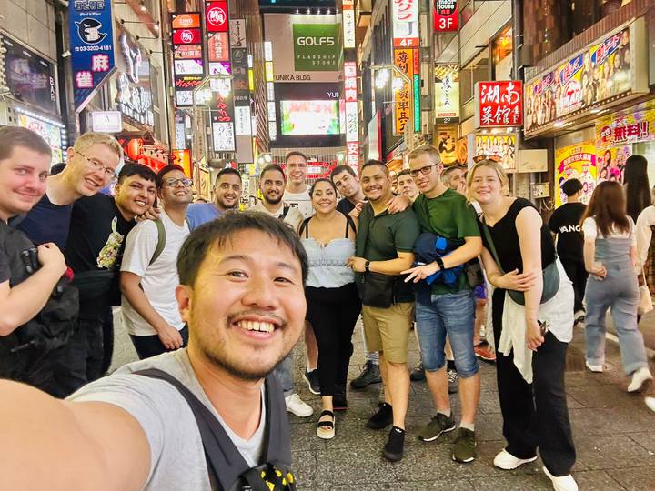 A group of friends enjoying an outing in a lively area with bright signage.