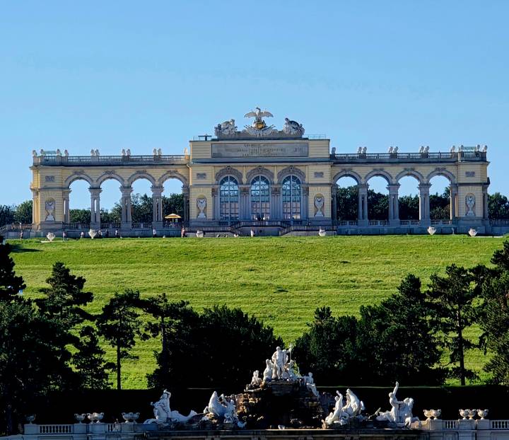 A historic building with archways on a grassy field.