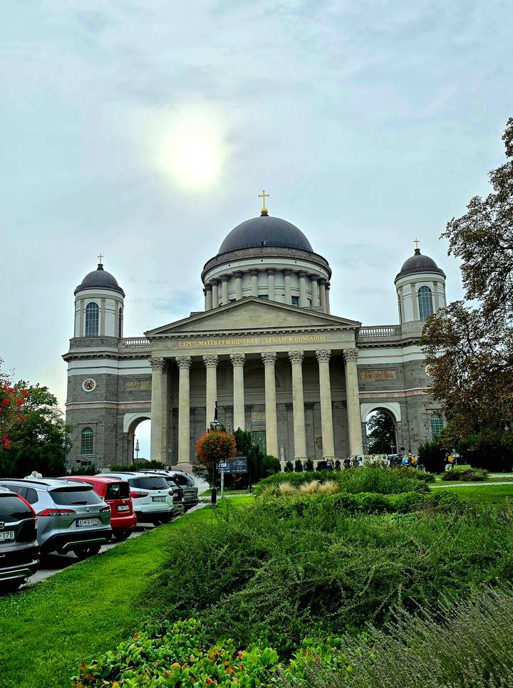 Front view of a large cathedral with numerous people.