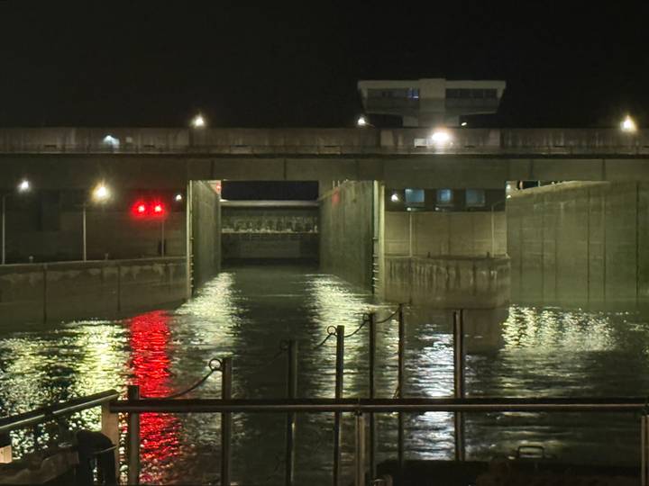 Night view of a river lock with lights reflecting on water