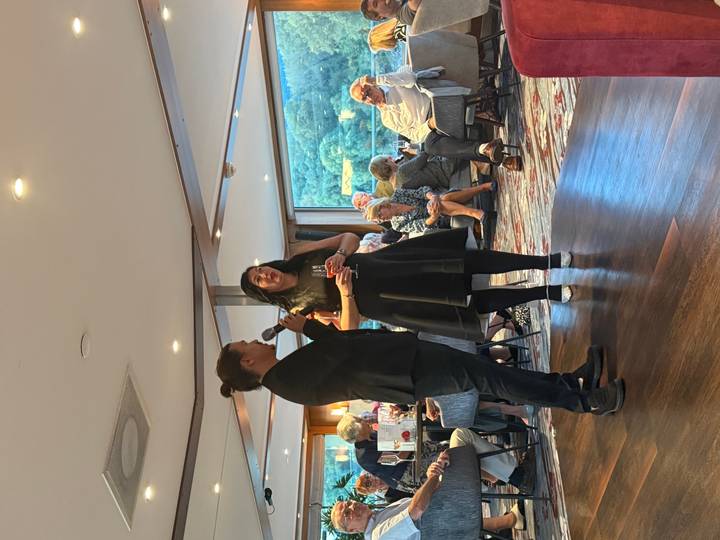 Two people speaking to an audience at an event