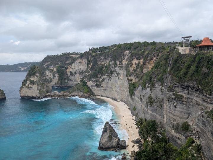 Cliffside beach with clear blue waters.