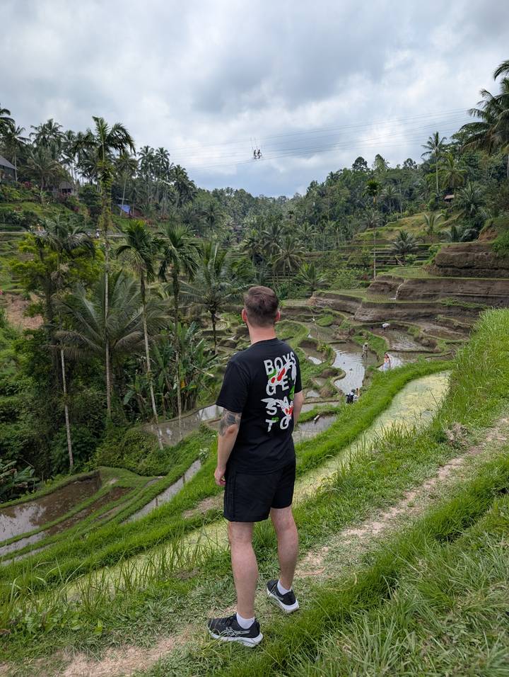 Person enjoying a view of terraced rice fields.