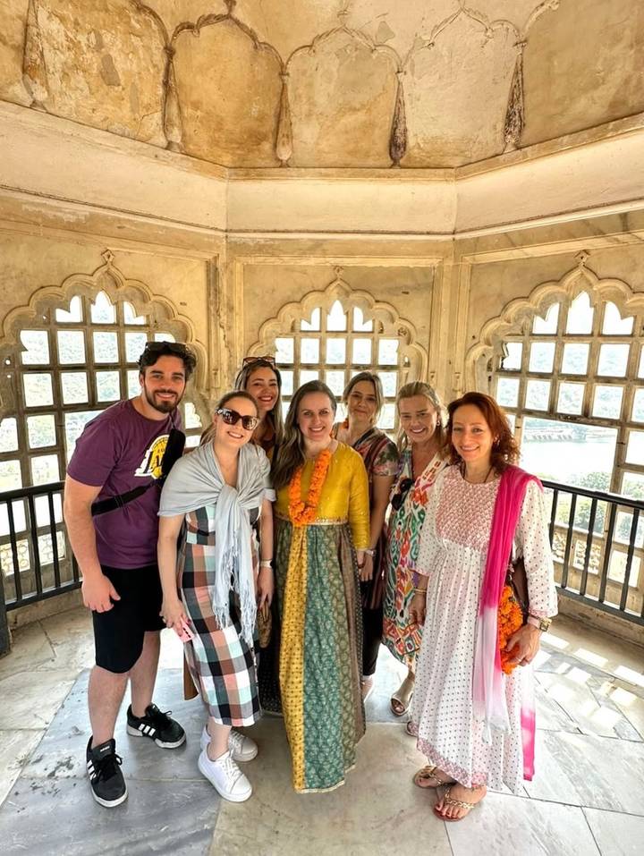 Groupe de personnes à l'intérieur d'un bâtiment historique avec des fenêtres en pierre.