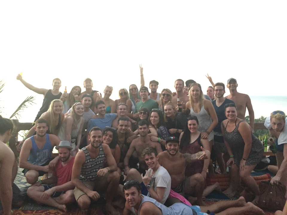 Large group of people posing together for a photo during day.
