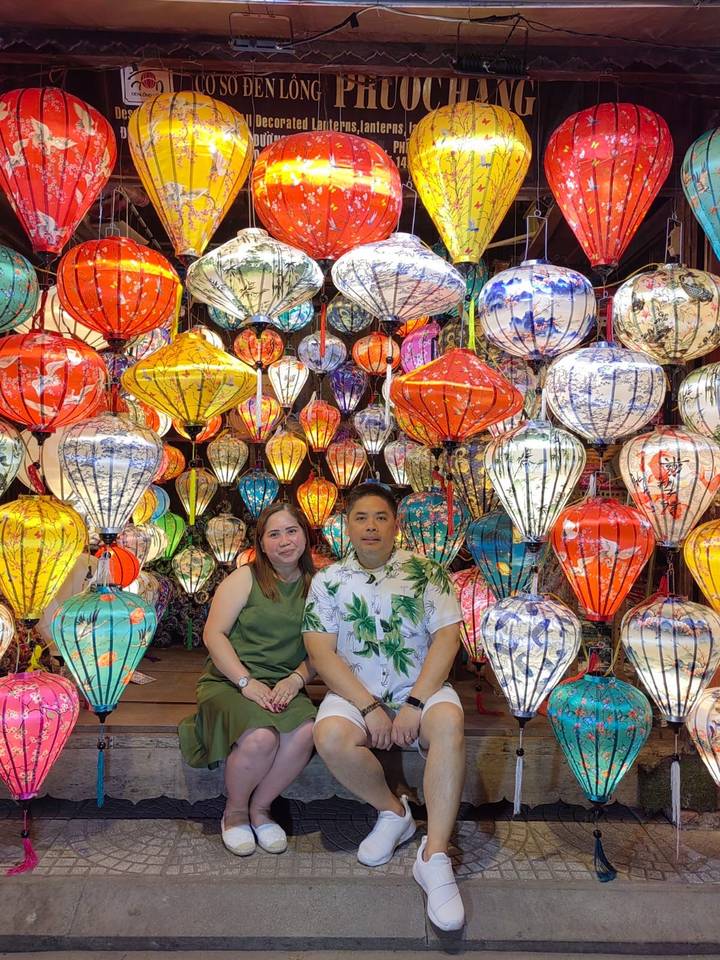 Couple sitting with colorful traditional lanterns in the background.