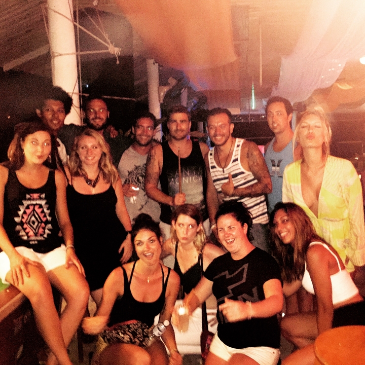 Group photo of people during a party with a dim background.