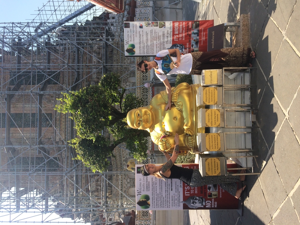 People posing with a golden statue; scaffolding in the background.
