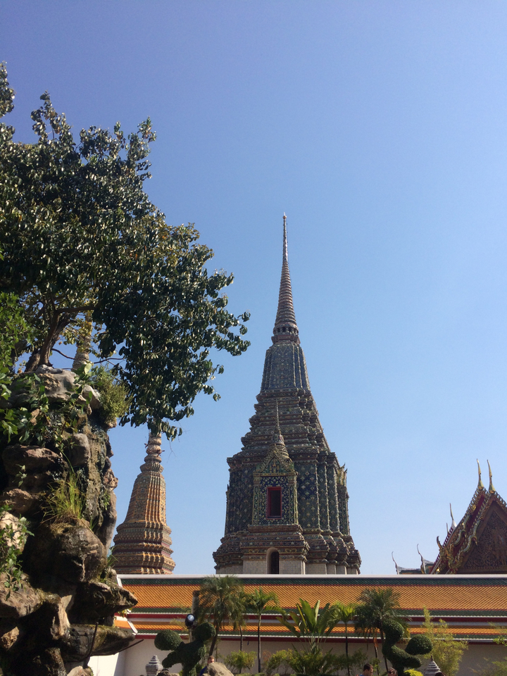 Tall temple spire with decorative patterns and trees.