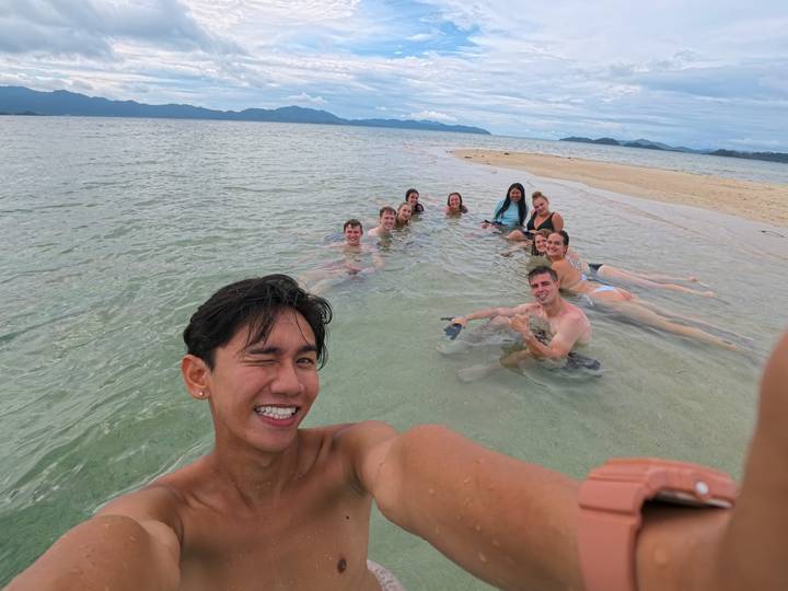 Groep mensen die genieten van tijd in ondiep zeewater.
