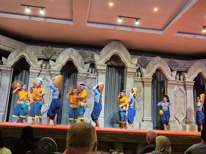 Traditionele dansvoorstelling op een podium met ingewikkeld decorontwerp.
