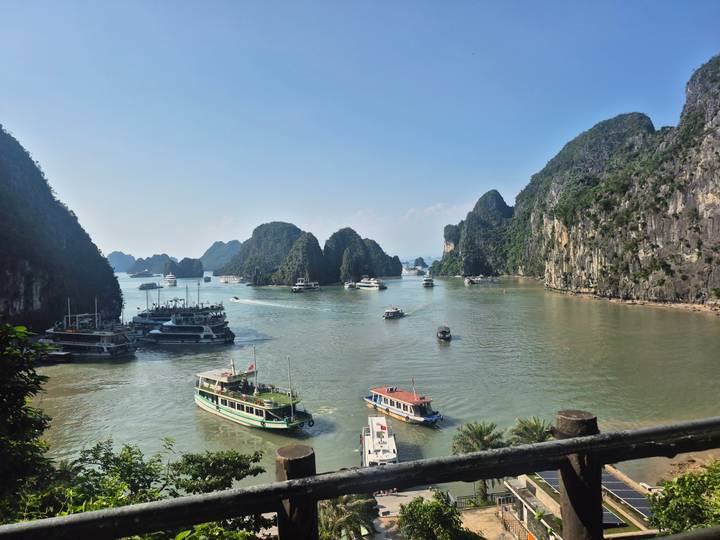 Schilderachtig uitzicht op boten in de wateren van Halong Bay, omgeven door kalkstenen kliffen.