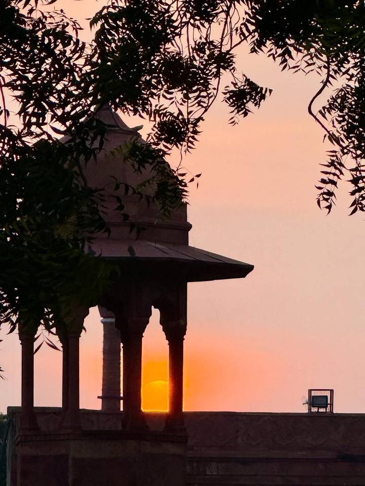 Silhouette d'une structure de toiture au coucher du soleil.