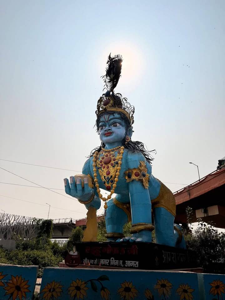 Grande statue bleue avec des ornements tenant un bol.