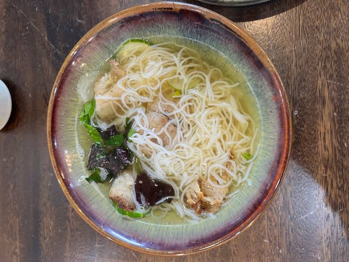 Bowl of noodle soup with vegetables.