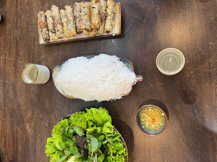 Plate of noodles with lettuce and dipping sauce.