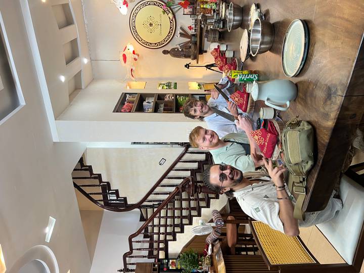 Three people sitting at a table in a cooking class.