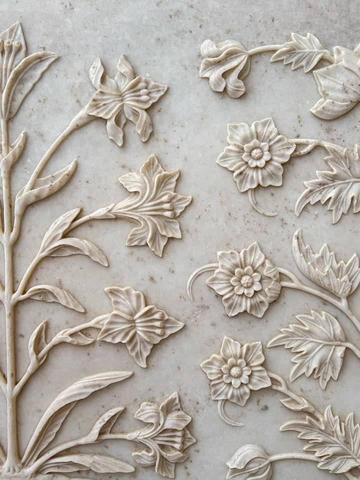 Sculptures florales complexes sur surface de marbre.