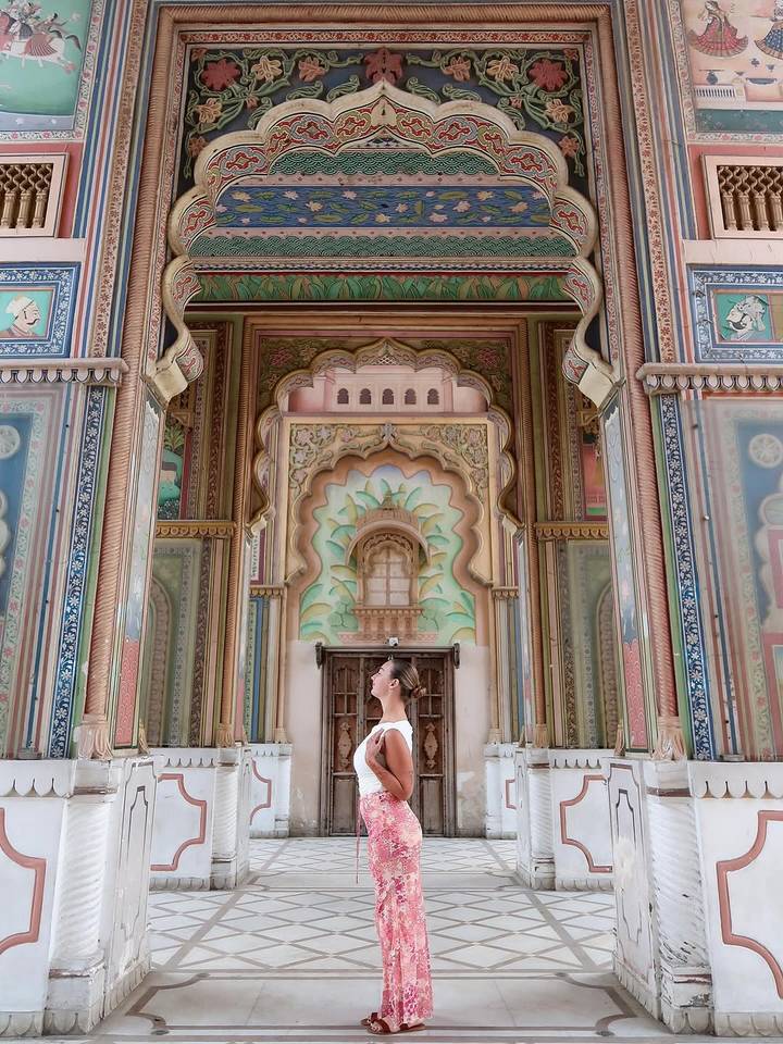 Femme debout dans une arcade richement décorée.