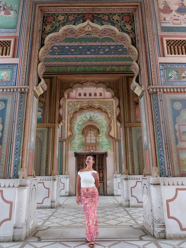 Femme en robe blanche debout dans un cadre orné.