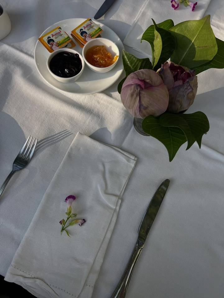 Dressage de table avec un arrangement floral sur une nappe blanche.