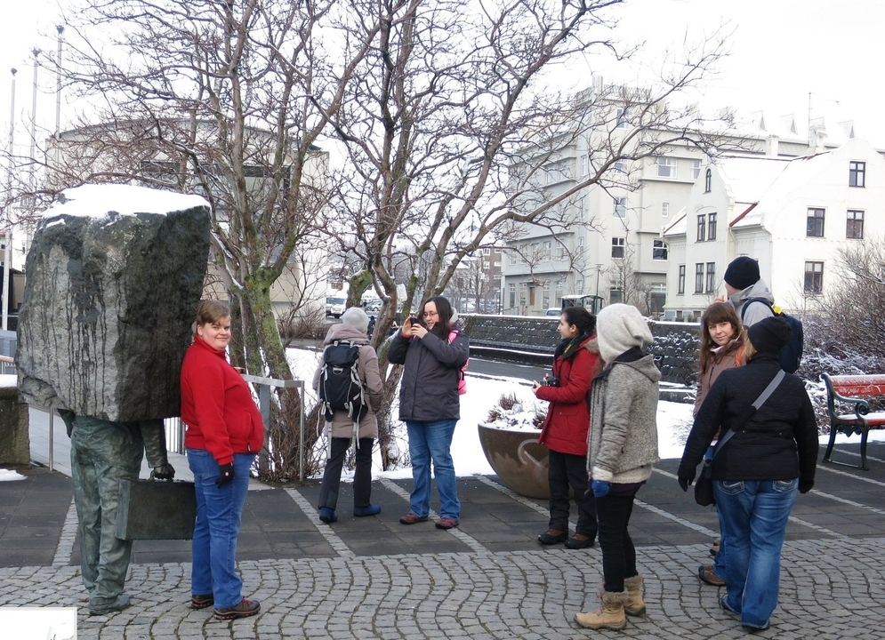 Des personnes prennent des photos d'une sculpture dans un environnement enneigé.
