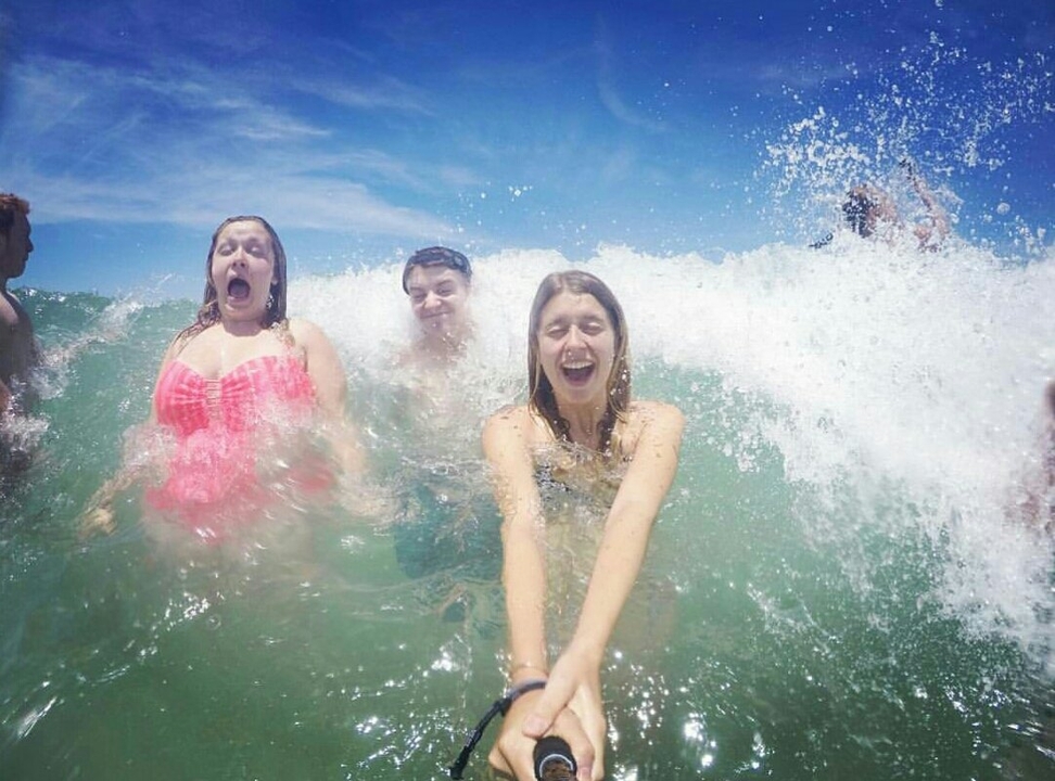 People enjoying waves at the beach.