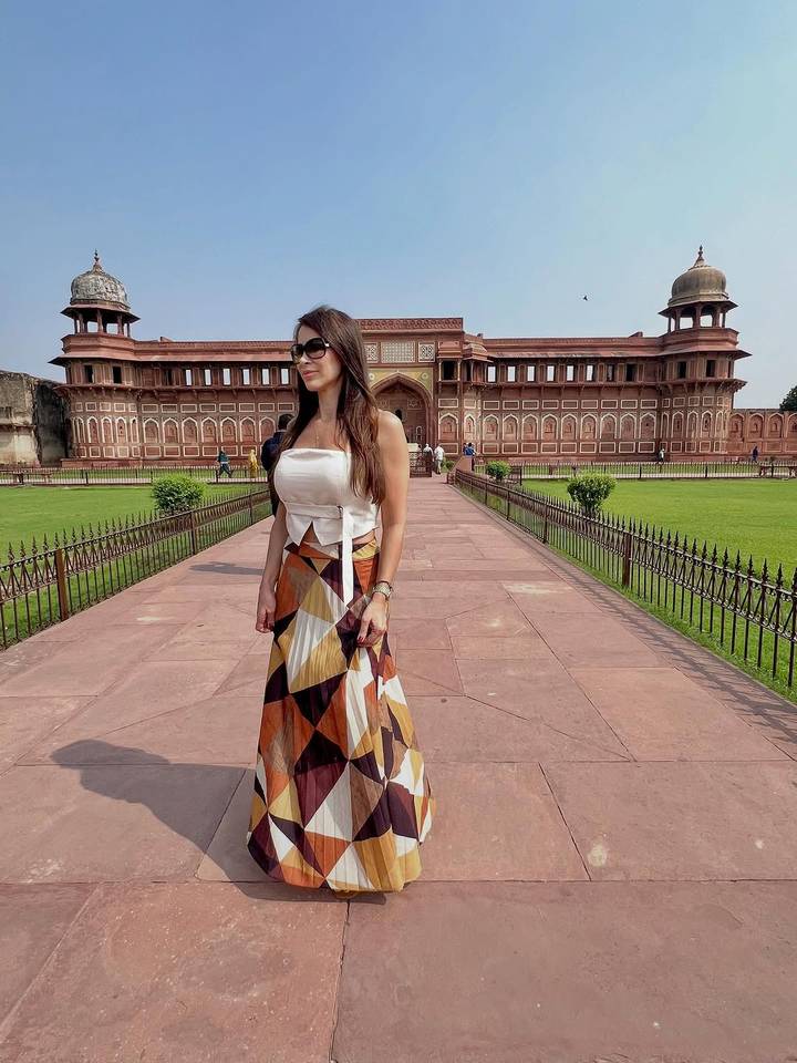 Femme posant devant un fort historique.