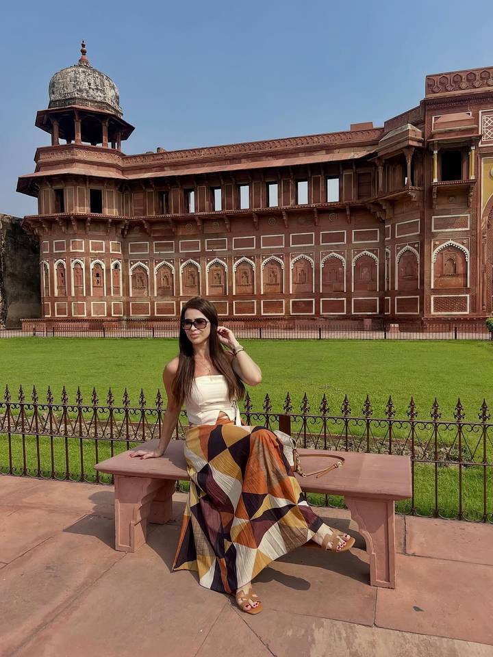 Femme assise devant un fort historique.