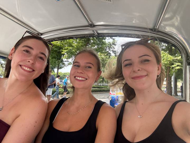 Drie mensen lachen in een voertuig.