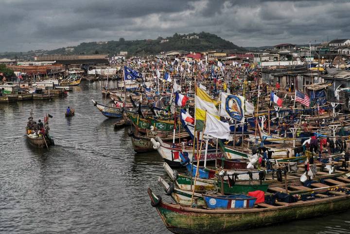 Crowded fishing port with numerous boats and colorful flags.