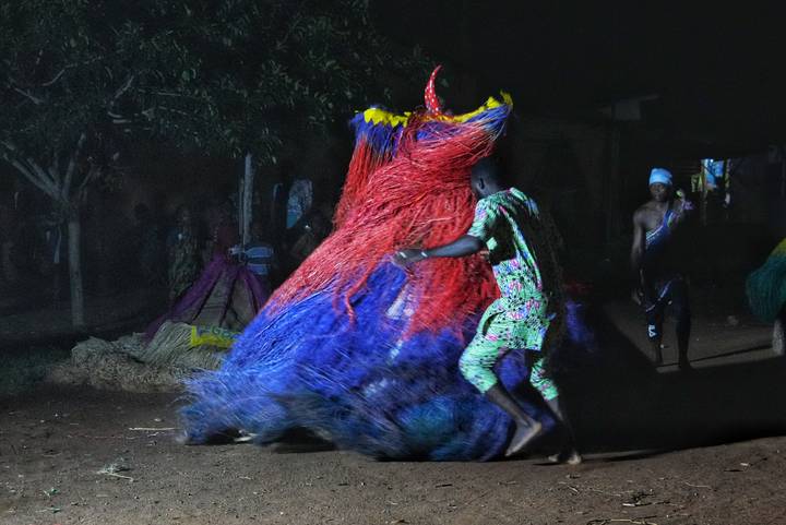 People dressed in colorful traditional costumes participating in a dance.