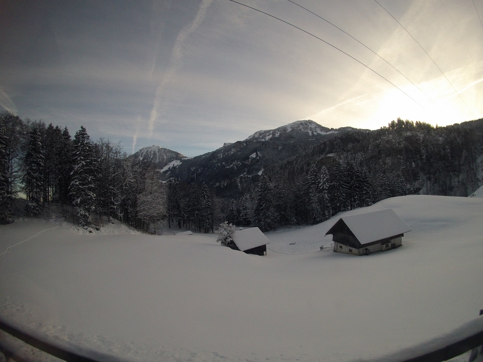 Snow-covered mountain landscape with wooden cabins.
