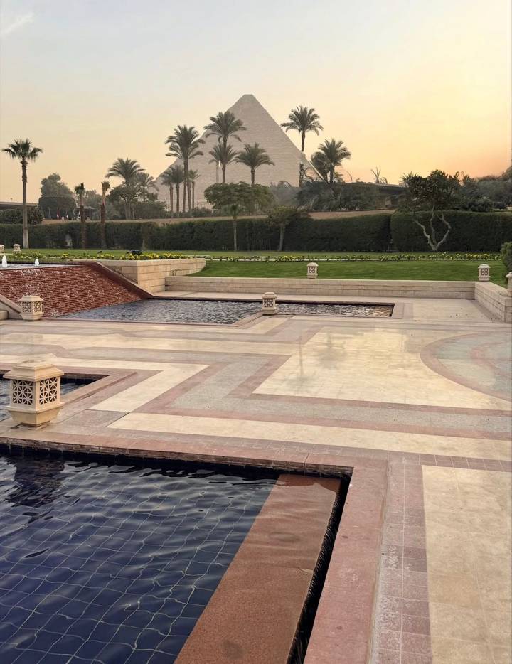 Landscaped garden with fountains and hedges.
