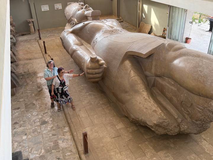 Zwei Menschen neben einer riesigen Statue in einem Museum.