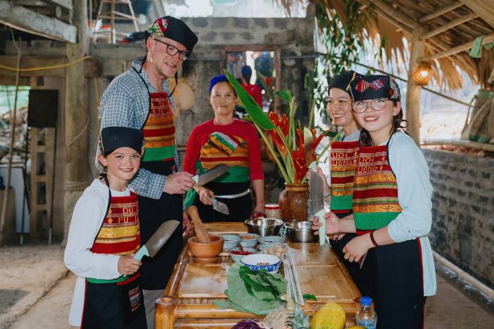 Groupe de personnes souriantes posant avec des ingrédients de cuisine.
