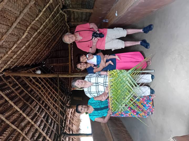 Familie poseert in een rustieke hut met handgemaakte ambachten in de etalage.