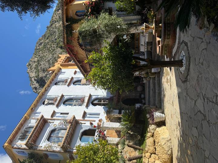 A Moroccan courtyard with traditional architecture and mountain backdrop.