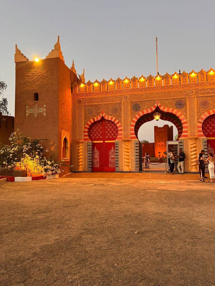 Entrée ornée avec des portes rouges et des décorations florales.