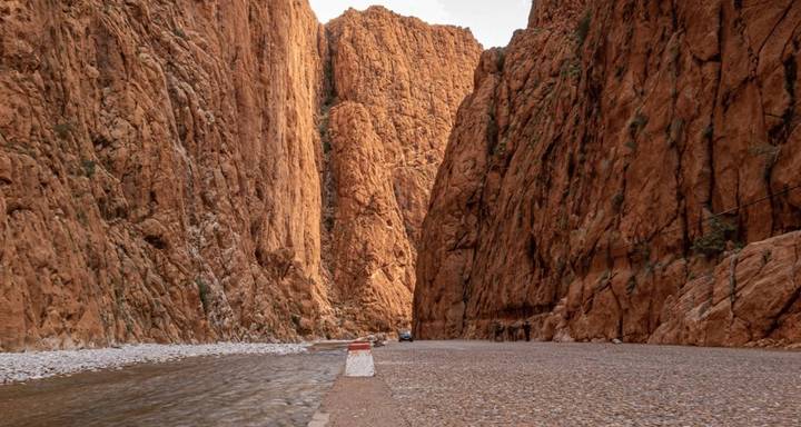 Paysage de canyon dramatique avec une route étroite et des parois abruptes.