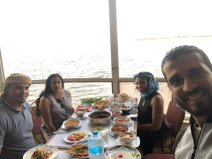 Gruppe von Menschen, die eine Mahlzeit am Wasser genießen.