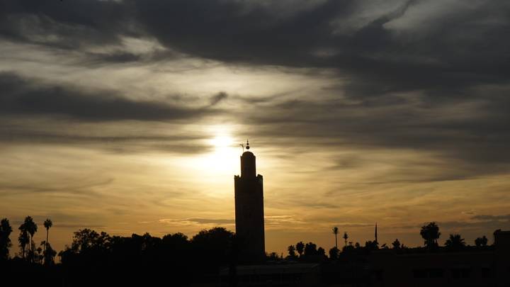 Silueta de una torre durante una puesta de sol dramática.