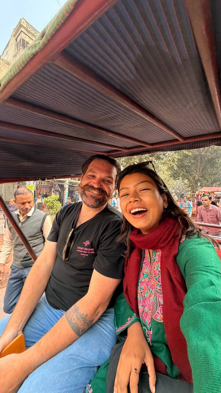 Des personnes souriantes dans un pousse-pousse dans un environnement urbain.