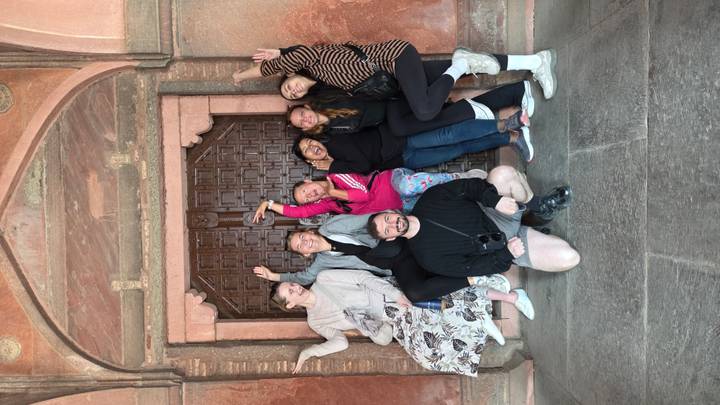 Groupe de personnes posant énergiquement près d'une porte traditionnelle.