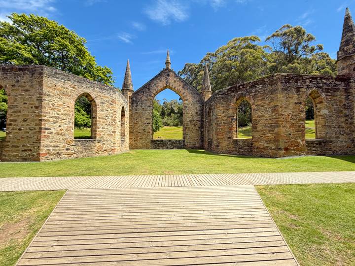 Historische ruïnes omringd door weelderig groen en heldere luchten.