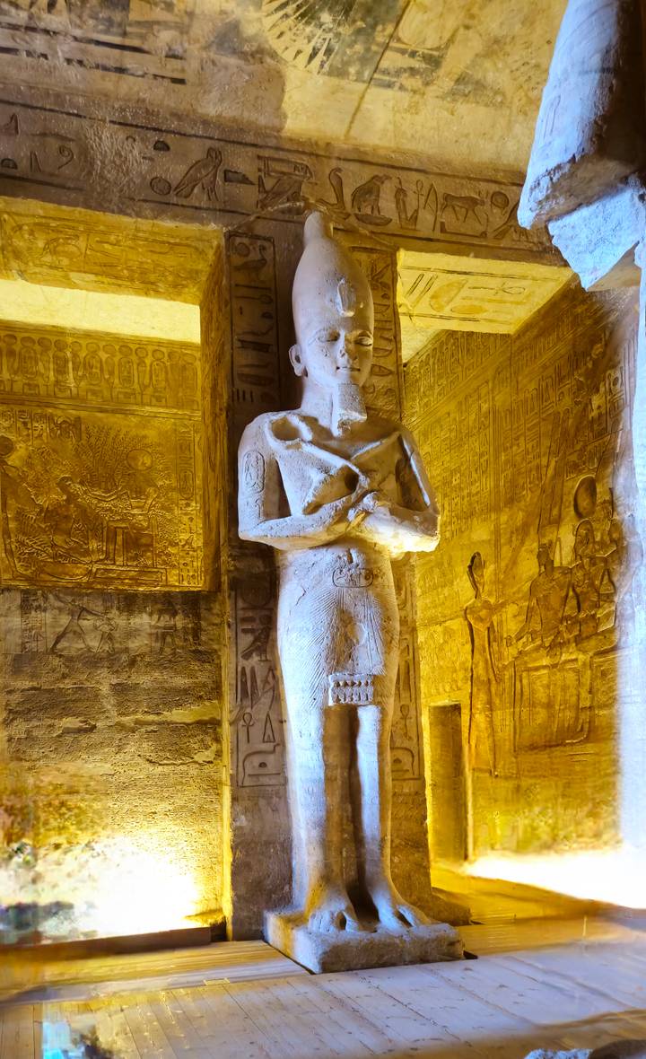 Intérieur bien éclairé d'un temple égyptien antique avec des sculptures et des statues.