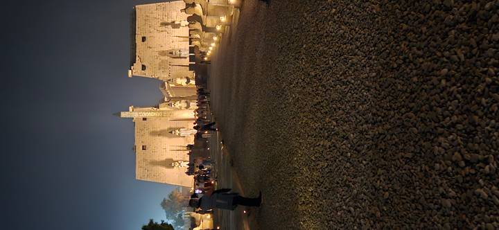 L'entrée du temple de Louxor illuminée la nuit avec des visiteurs qui explorent.