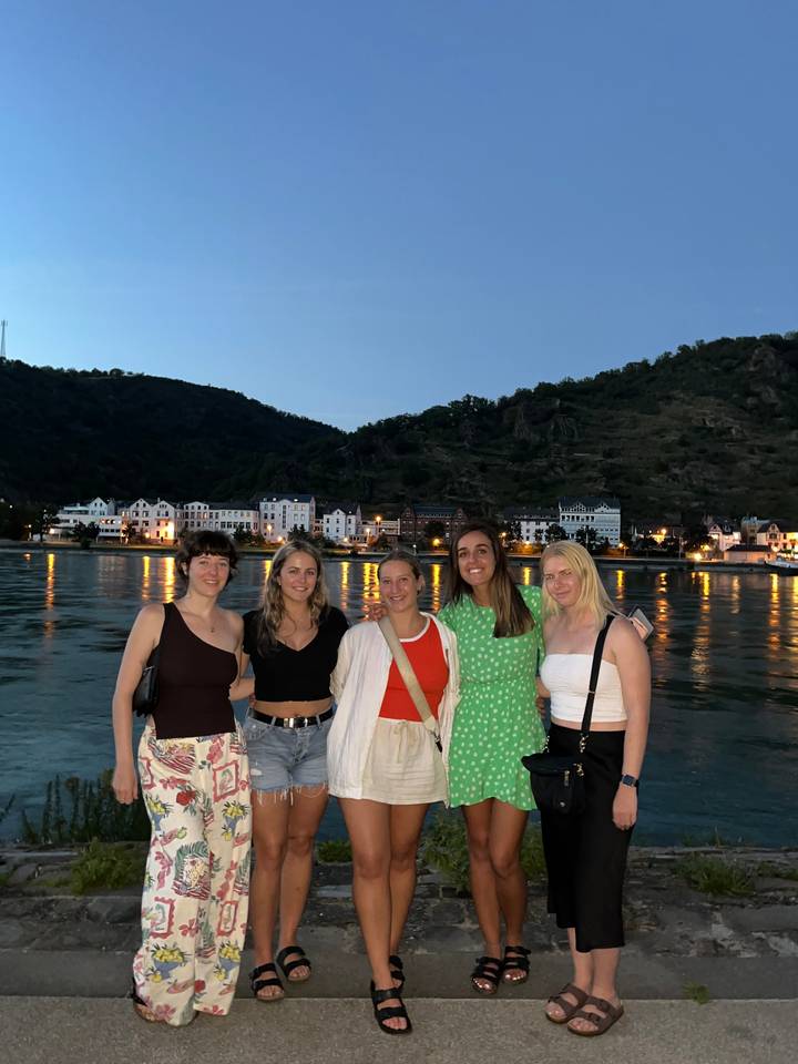 Group of women posing by the waterfront in an evening setting.